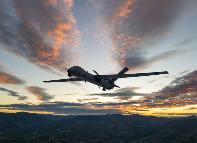 Military UAV spy drone flying over at the sunset